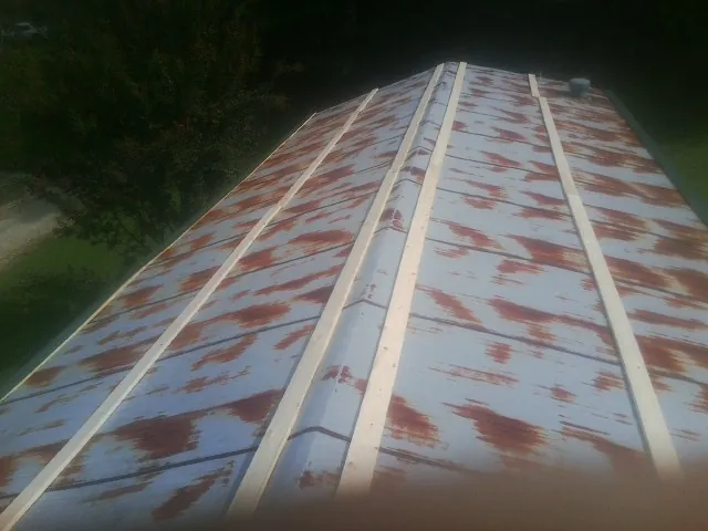 Rusted metal roof panels with new wood purlins before replacement — Storm Damage Roof Repair in Higden by Roofing Brothers