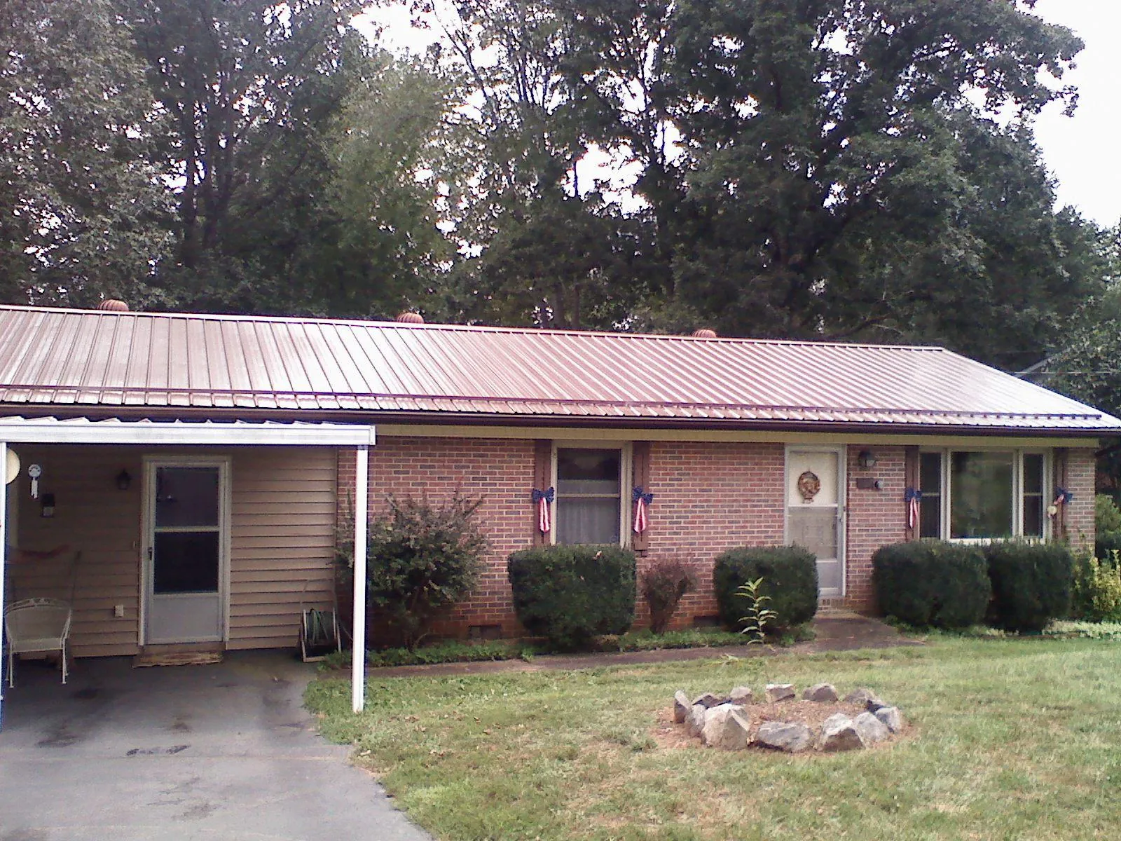 Bronze metal roof and carport on a brick ranch home — Roof Repair work by our crew in Higden